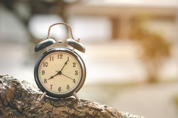 Black alarm clock on bokeh nature background