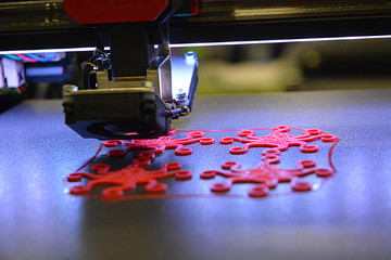 Accurate 3D Printing Machine printing a piece of red plastic. Working 3d printer.