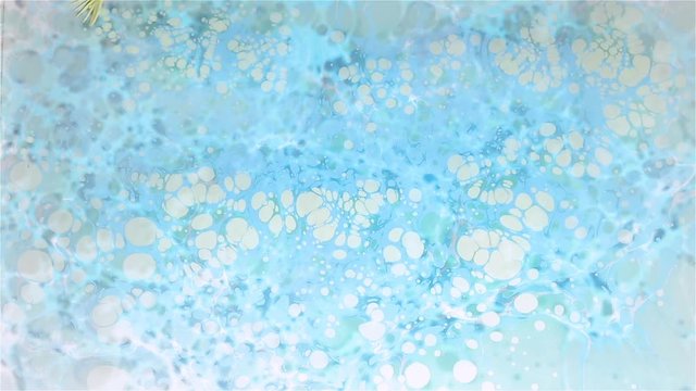Artist creates absractive ebru design with orange, pink and white paints