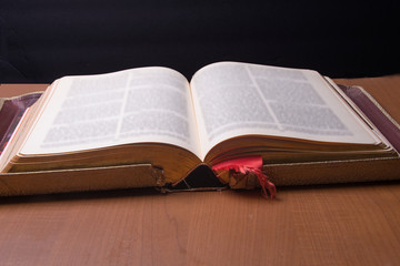 Old book laying on a table showing wear and tear from being  used over the years.