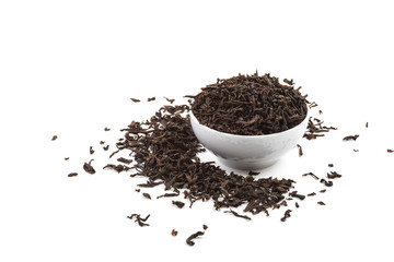 Dried tea leaves in ceramic cup over white background.