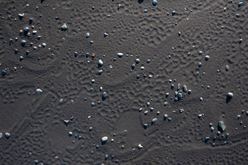 Black volcanic sand waves abstract background texture with copyspace. Black beaches of Iceland.