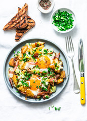 Potatoes, ham, eggs breakfast hash on a light background, top view. Delicious, nutritious...