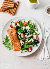 Healthy balanced lunch - grilled red fish fillet salmon and tomatoes, cucumbers, olives, feta Greek...