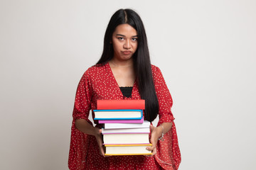 Unhappy young Asian woman studying  with may books.