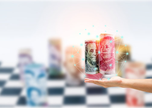 USA and China trade tariff war concept. US dollar and Yuan banknote on hand with blurred international banknote on chess table.
