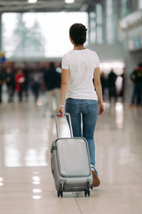 traveler young woman walking with suitcase in an airport