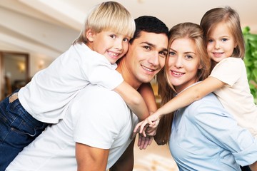Obraz na płótnie Canvas Young family at home smiling at camera