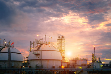 Petrochemical plant on sunset sky background with gas storage sphere tanks, Manufacturing of...