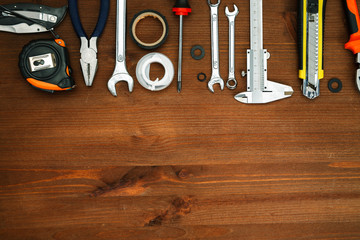 Different tools on a wooden background, top view, space for text