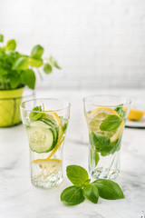 Infused water with lemon, cucmber and basil on white