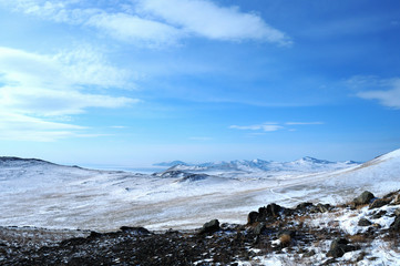 Early morning sunrise in Tazheran steppes. Snow-covered hills are colored in shades of ultra-violet. Photo toned.