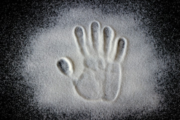 Handprint on the scattered sugar. Concept is healthy eating, diet, control and weight loss
