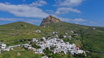 Fototapeta na wymiar Aerial drone photo of picturesque village of Tripotamos in the slopes of mountain and of Exomvourgo or Exombourgo with beautiful deep blue sky, Tinos island, Cyclades, Greece
