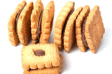 Peanut butter cookie on a white background. Golden homemade biscuit with a missing bite and trail of crumbs.