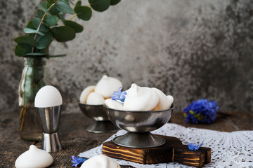 Homemade white meringue of egg whites on aged wooden table