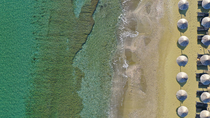 Aerial top view photo of Mykonos island deep turquoise super paradise beach with sun beds and...