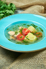 Red fish soup in a blue plate. Beautiful serving dishes. Restaurant menu