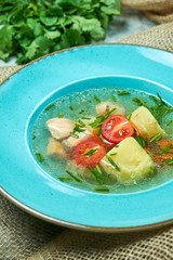 Red fish soup in a blue plate. Beautiful serving dishes. Restaurant menu