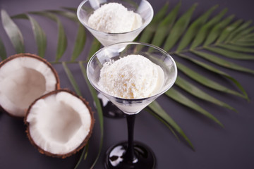 Coconut ice cream on the black background with palm leaf and coconut