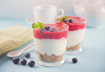 Bowls of breakfast healthy muesli with blueberry, strawberry and yogurt.