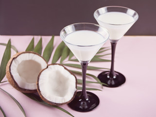 Pina Colada cocktail with palm leaf and coconut on the background