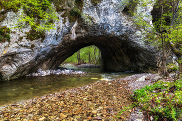 Rock formation "Shapran hole" with river under the tunnel in Rhodope mountain, Bulgaria