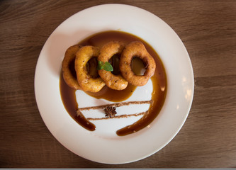 Traditional peruvian dessert Picarones. Made of sweet potato, pumpkin and wheat flour. Fried an served whit honey figs.