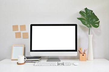 Personal computer and notebook, coffee with pant on office desk, creative workspace.