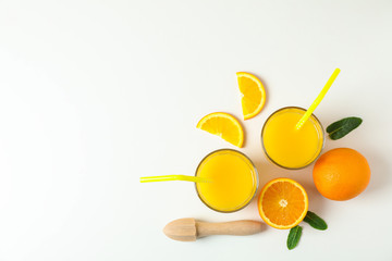 Fototapeta na wymiar Flat lay composition with fresh orange juices, wooden juicer, mint, oranges and wooden juicer on white background, top view and space for text. Fresh natural drink and fruits