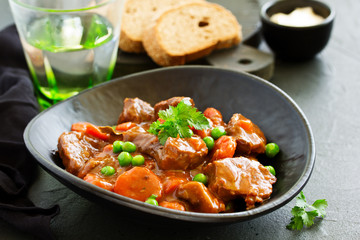 Beef stew in Burgundy. With carrots, onions, peas and champignons in wine. View from above.