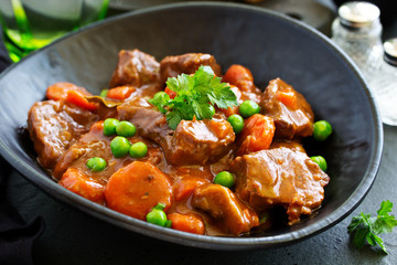 Beef stew in Burgundy. With carrots, onions, peas and champignons in wine. View from above.