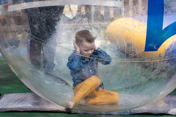 Water or aquac zorbing. Children play inside the inflatable transparent ball floating in swimming pool. Water walking or zorbing very popular fun activity and suitable for all ages.