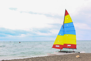 Colorful sailing boat on the beach on a cloudy day