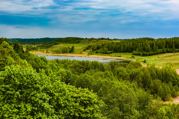 Fototapeta na wymiar beautiful rural summer landscape with forest, river, blue sky and white clouds.