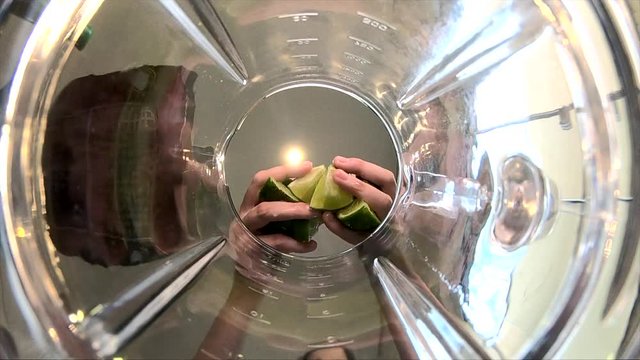 Pieces of lemon falling into the blender in super slow motion