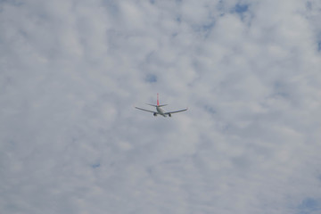 Passenger airplane fly on a hight above overcast clouds and blue sky