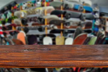 Mockup. Image of sport store with equipment for skiing. Defocused, blurred image. In the foreground is the top of a wooden table, counter.