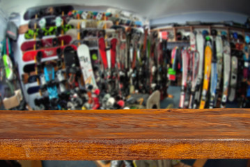 Fototapeta premium Mockup. Image of sport store with equipment for skiing. Defocused, blurred image. In the foreground is the top of a wooden table, counter.