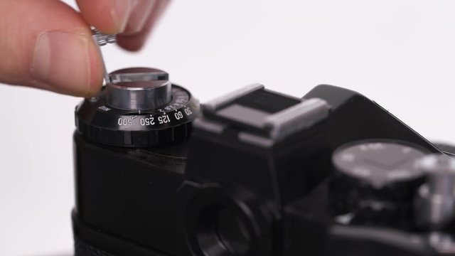 A close-up of a photographer demonstrating single-lens reflex camera work. Changing settings on camera mode deal.