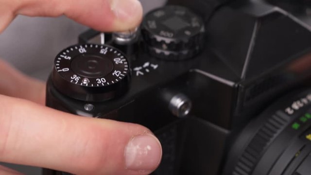 An expert photographer taking pictures using old technology single-lens reflex camera. Isolated, on white background