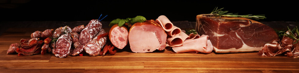 cold meat assortment with delicious salami and  fresh herbs . Variety of meat products including...