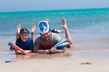 Tata nurkuje z dzieckiem w morzu i spędza wakacje na plaży