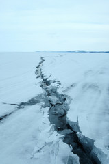 Ice hummocks on the northern shore of Olkhon Island on Lake Baikal. Fresh crack broke the thick ice. Fresh clean water rises from the depths and freeze in the cold. Ice Storm. Photo partially tinted