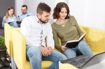 Man and woman with book in hostel lobby