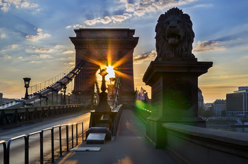 The rising sun shines through the arch of the famous Chain Bridge. Badapesht, Hungary.