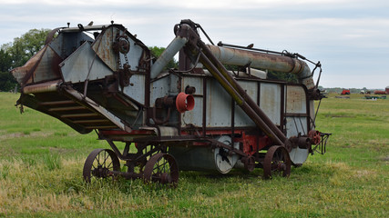 antique combine harvester in wheat field