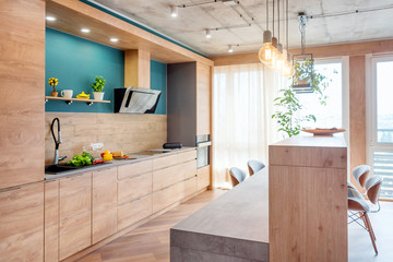 Modern furniture in luxury kitchen. Minimalist scandinavian interior in loft apartment with wooden...
