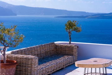 Fototapety  Table and sofa on a tarrace with view of Aegean Sea in Oia. Santorini, Cyclades, Greece