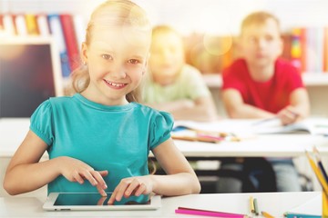 Smiling School Girl in the Classroom Using Tablet